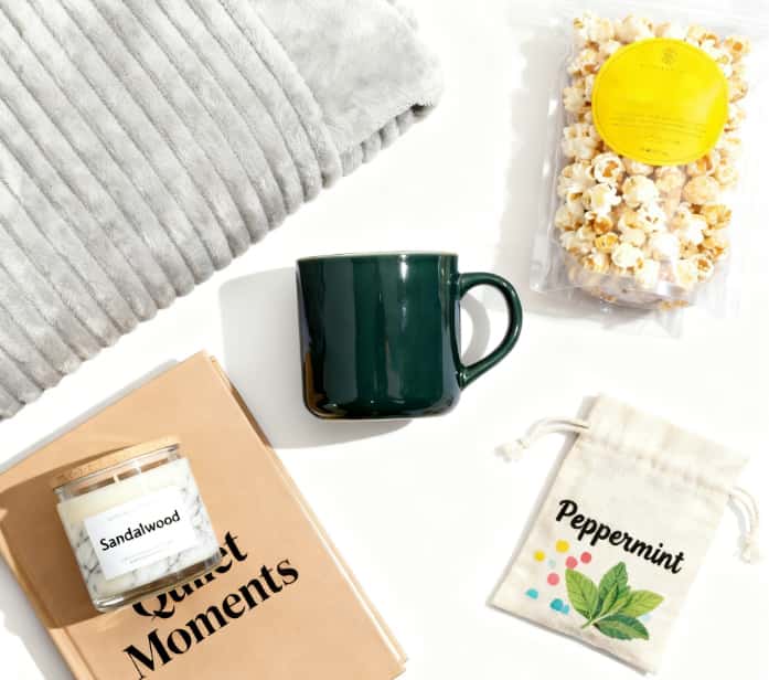 Cozy night in gift kit with a soft blanket, mug, snacks, and a candle for relaxation