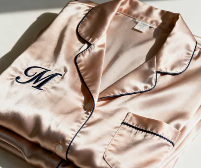 Beautifully folded silk pajamas with elegant embroidered monograms.