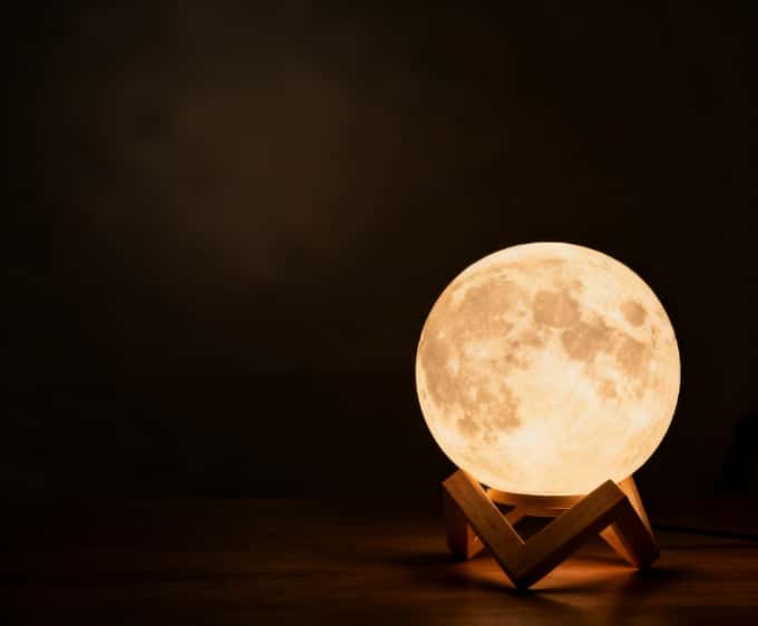 Moon phase projector light creating a dreamy and calming atmosphere for relaxation and sleep.