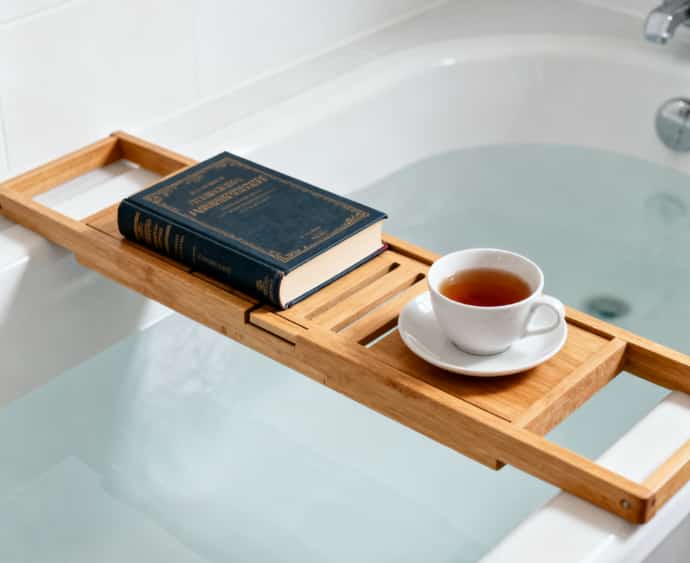 Solid wood bath caddy to hold a book and wine glass for a luxurious spa-like bath experience.