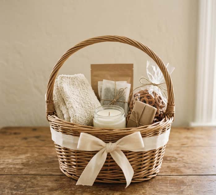Woven cozy night-in gift basket filled with tea candle and towel