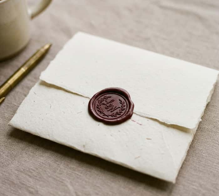 Wax sealed envelope on linen fabric with brass pen