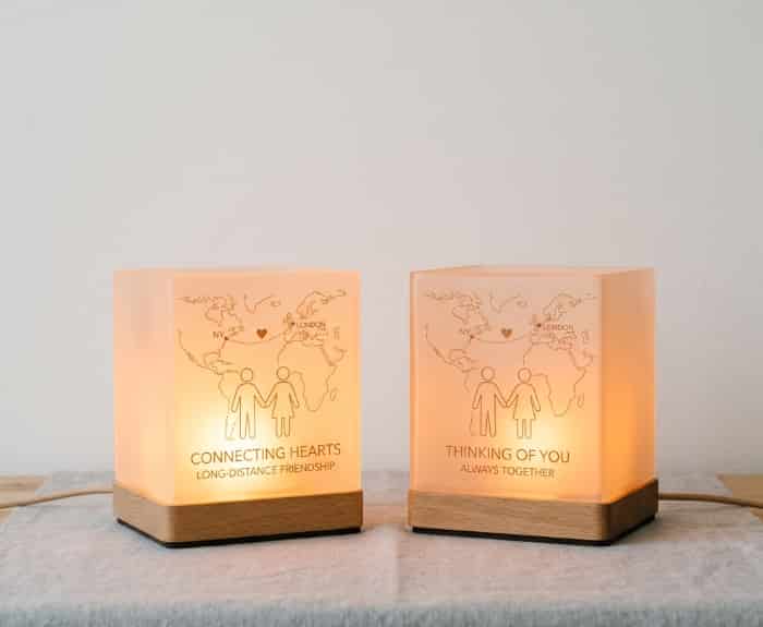Two glowing touch lamps on separate nightstands