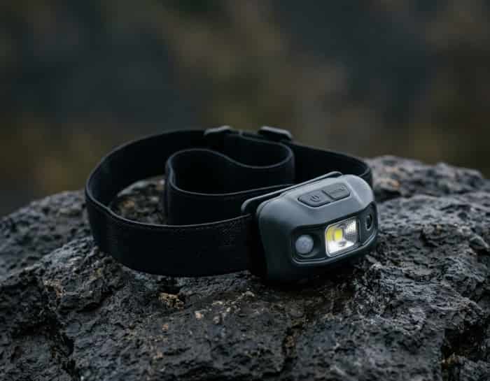Featherweight motion-sensing headlamp resting on a dark rock