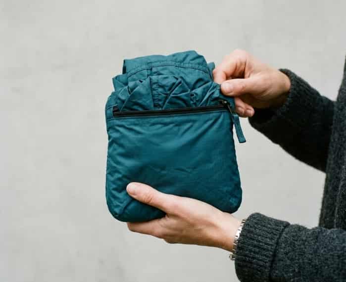 Packable recycled rain jacket stuffed into its own pocket