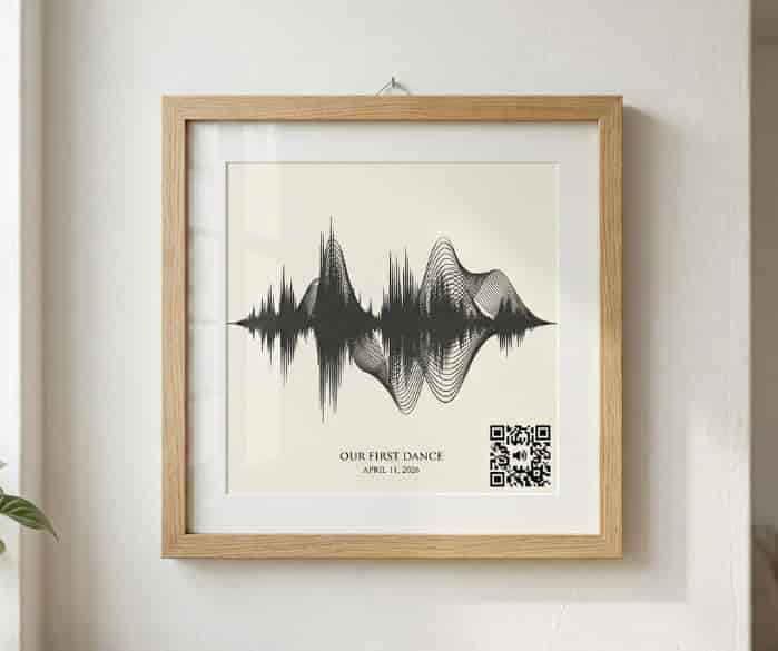 Framed custom soundwave art print with a QR code and personalized text hanging on a plain white wall