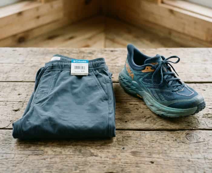 Quick-dry hiking joggers folded on wood with trail shoes