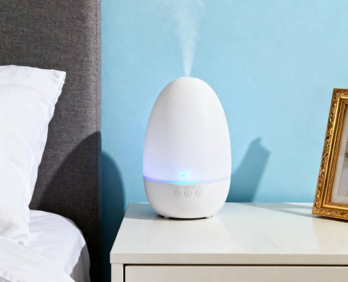 Smart aroma diffuser misting on a nightstand