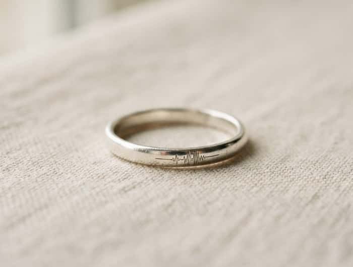 Silver band ring with an engraved custom soundwave pattern