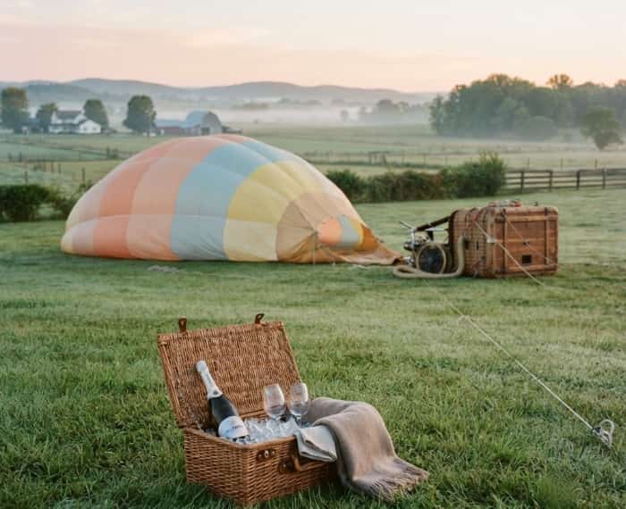 Hot air balloon inflation on a grassy field at sunrise for a romantic date
