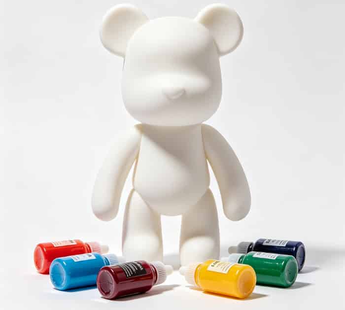 DIY fluid art kit with a blank bear figure and acrylic paints