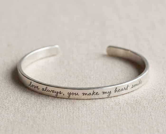 Thin metal bracelet engraved with handwritten script