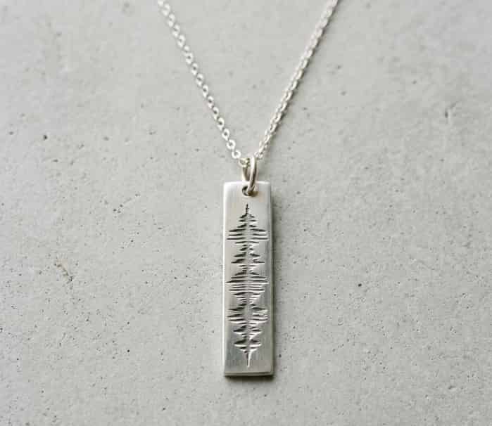Silver necklace with a custom soundwave pattern pendant