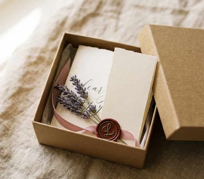 handwritten note tucked inside personalized gift box with ribbon and dried flowers