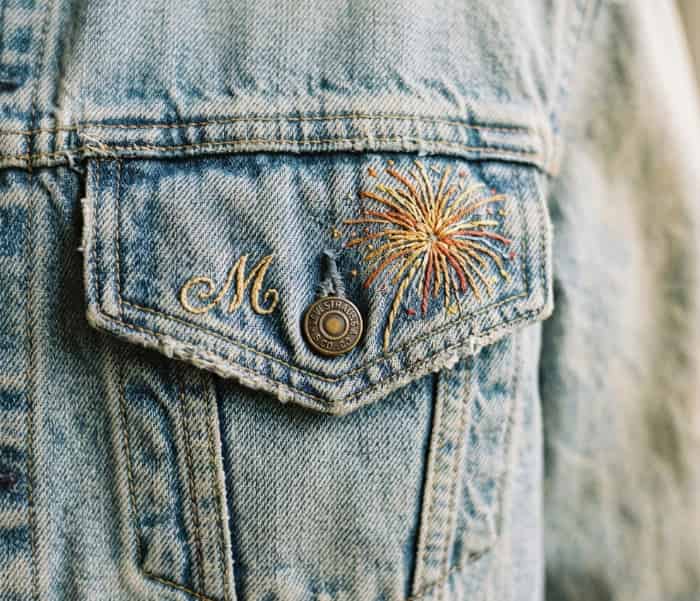 Vintage denim jacket pocket with custom embroidered initial and tiny firework