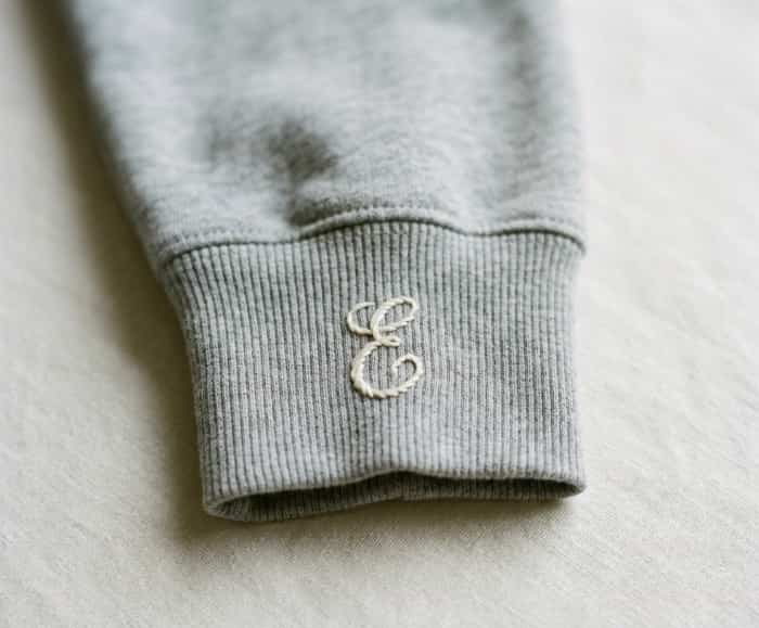 Close-up of a custom hand-embroidered initial stitched onto a hoodie cuff