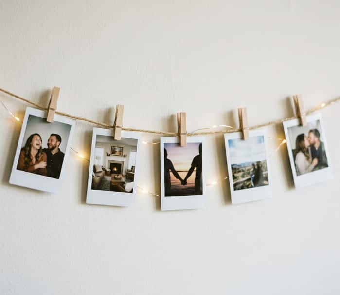Mini polaroid pictures clipped to twine with wooden pegs and warm fairy lights